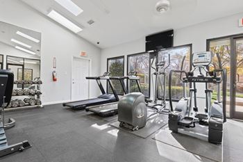 A gym with treadmills, weights, and exercise equipment.